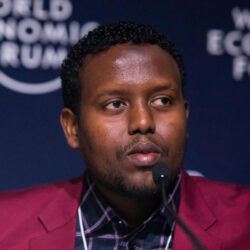 Mohammed Hassan
Mohammed is Ambassador for StepUp.One and was a Co-Chair, World Economic Forum, Davos in 2019. He was a formerly Zonal Chairman at Keny’s Kakuma Refugee Camp. Born in Somalia he was confined there for more than twenty years with no passport, no birth certificate, no opportunities, no hope. In a broadcast from Kakuma to the World Economic Forum Annual Summit at Davos, he called for a reframing of global conceptions of displaced peoples: ‘It’s high time that refugees are seen as partners in development efforts, rather than a burden to society. We have people with talents who, given a chance, can perform.” This brief intervention inspired the 2019 formation of StepUp.One, an organisation dedicated to re-skilling people living in refugee camps and connecting them to opportunities that pay.